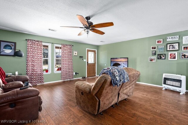 bedroom featuring ceiling fan, dark hardwood / wood-style floors, a textured ceiling, and heating unit