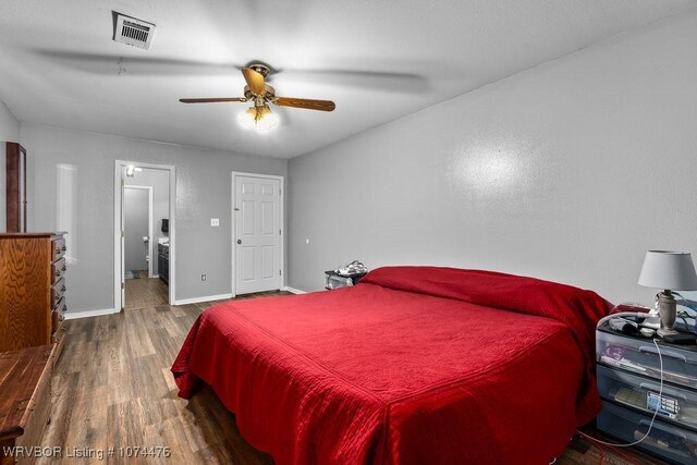 bedroom featuring connected bathroom, ceiling fan, and dark wood-type flooring