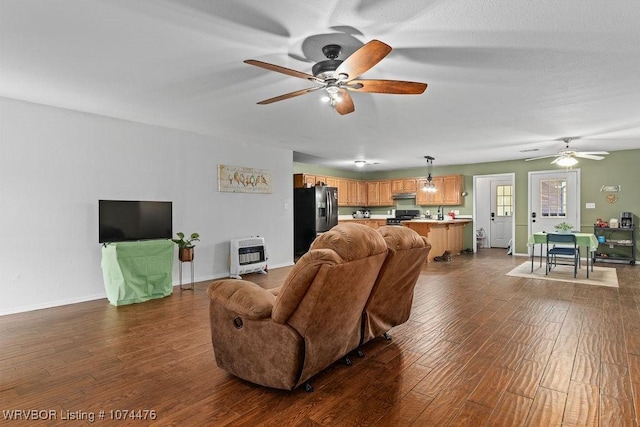 451 Hill St, Booneville, AR 72927 - living area featuring baseboards, heating unit, ceiling fan, and dark wood-style flooring