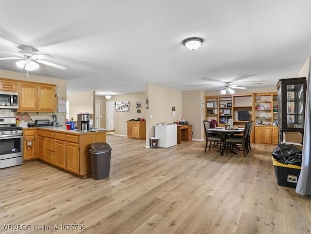 kitchen with ceiling fan, stainless steel appliances, kitchen peninsula, decorative backsplash, and light wood-type flooring