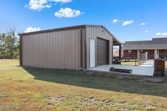 view of outdoor structure featuring a garage and a lawn