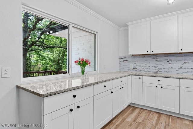 2420 Independence St, Fort Smith, AR 72901 - kitchen featuring ornamental molding, backsplash, light wood-type flooring, white cabinetry, and light stone countertops