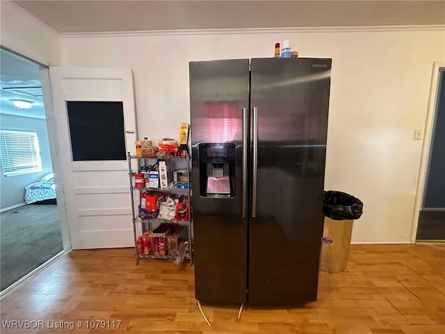 kitchen with light wood-style floors, ornamental molding, and stainless steel refrigerator with ice dispenser