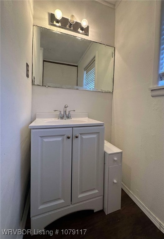 bathroom featuring wood finished floors, vanity, and baseboards