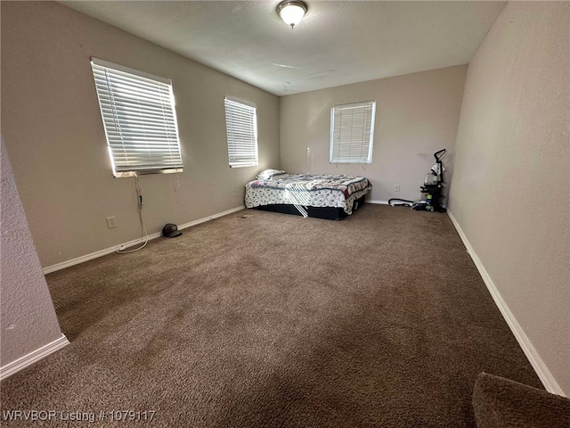 unfurnished bedroom with baseboards and carpet flooring