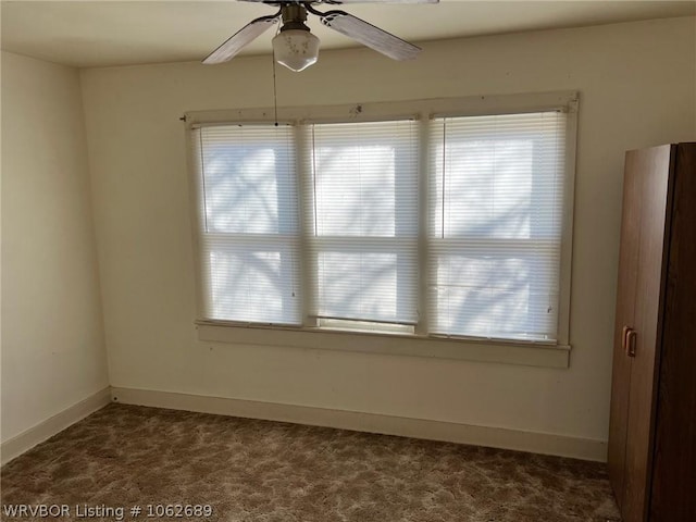 carpeted spare room featuring ceiling fan