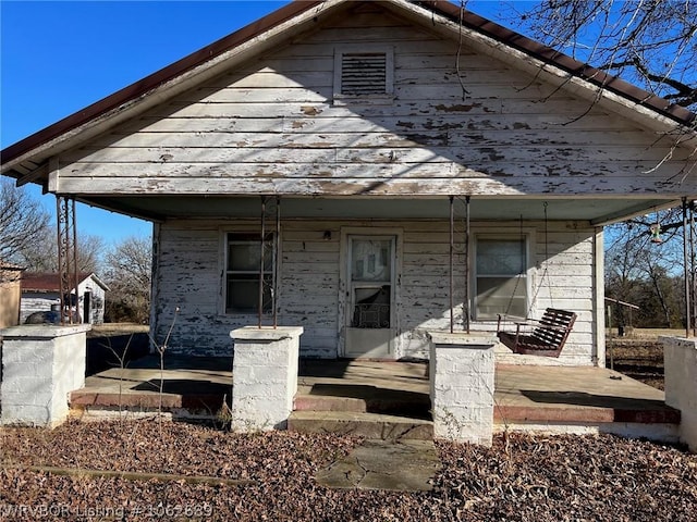 back of house featuring covered porch