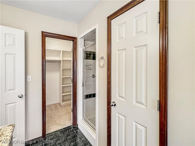 hallway featuring dark tile patterned flooring and dark carpet