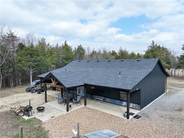 rear view of property with a fire pit and a patio area