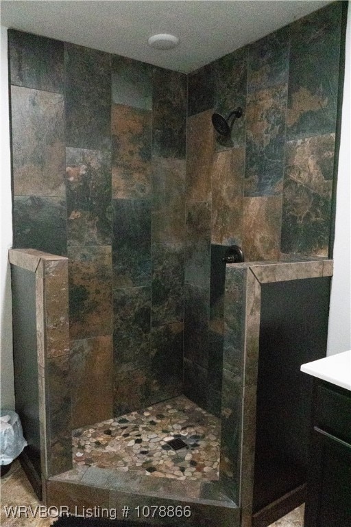 bathroom with vanity and tiled shower