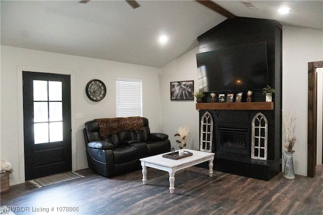 living room with vaulted ceiling, dark hardwood / wood-style floors, and a fireplace