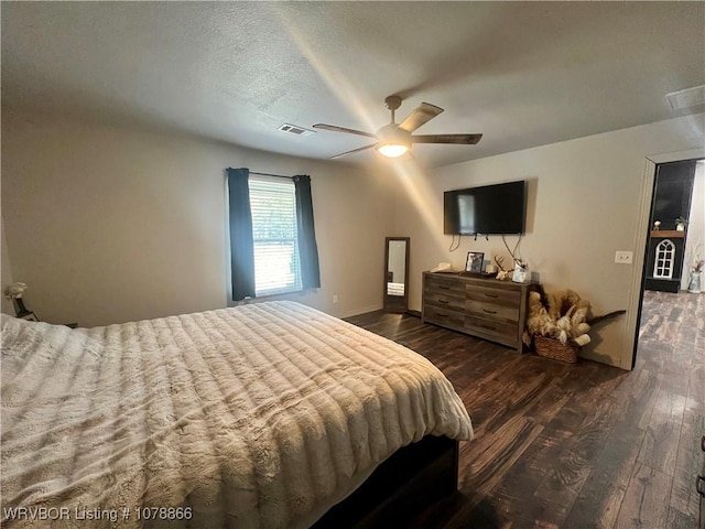 bedroom featuring a textured ceiling, dark hardwood / wood-style floors, and ceiling fan