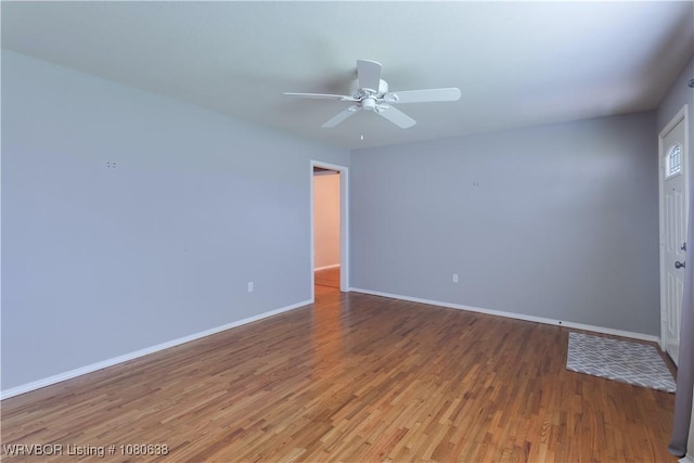 unfurnished room with baseboards, ceiling fan, and wood finished floors