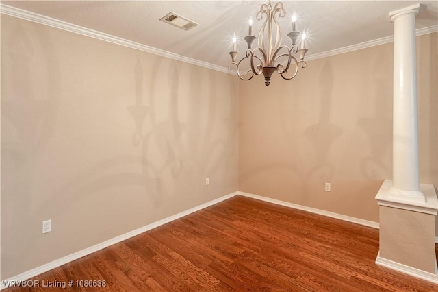 empty room featuring baseboards, ornamental molding, wood finished floors, and visible vents