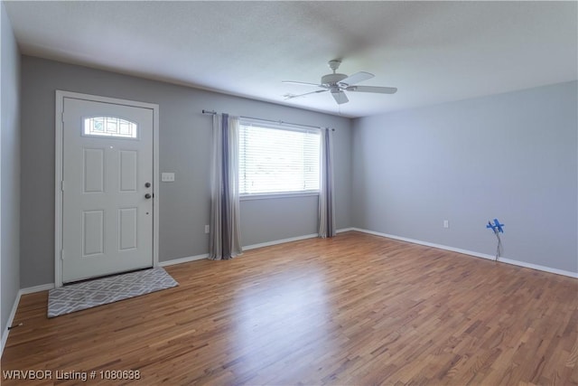 foyer entrance with baseboards, a ceiling fan, and wood finished floors