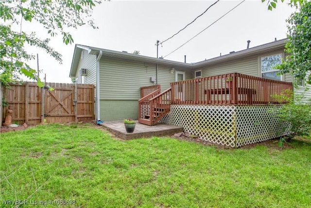 rear view of house featuring a lawn, a deck, a gate, fence, and stairs