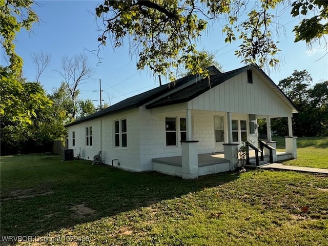 view of side of property featuring central air condition unit, a yard, and a porch