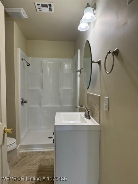 bathroom with vanity, toilet, and walk in shower