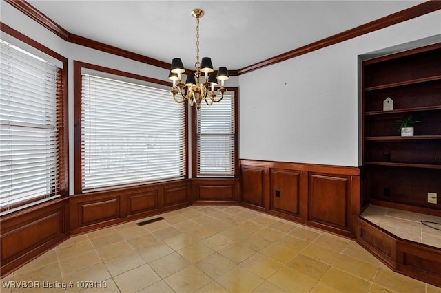 10408 Tweed Ln, Fort Smith, AR 72908 - unfurnished dining area featuring built in shelves, a notable chandelier, visible vents, ornamental molding, and wainscoting