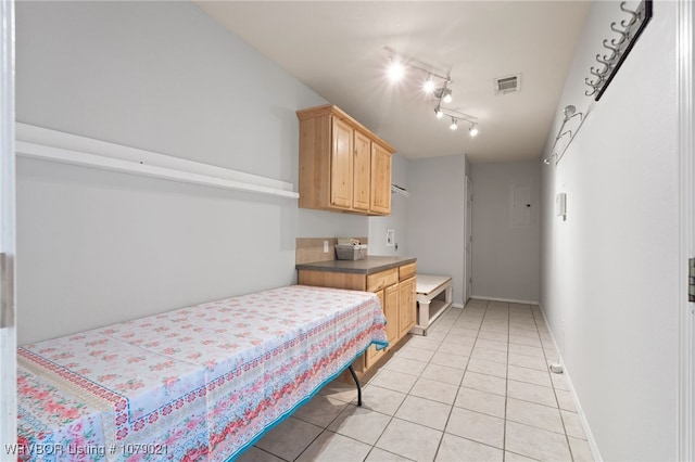 bedroom with rail lighting and light tile patterned flooring