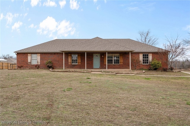 ranch-style home featuring covered porch and a front lawn