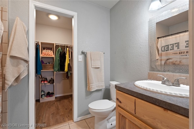 bathroom with tile patterned flooring, vanity, and toilet