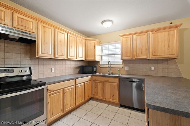 kitchen featuring tasteful backsplash, sink, light tile patterned floors, and appliances with stainless steel finishes