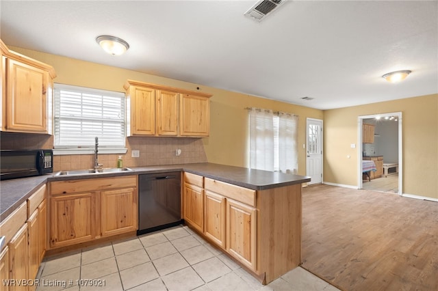 kitchen with sink, kitchen peninsula, decorative backsplash, and black appliances