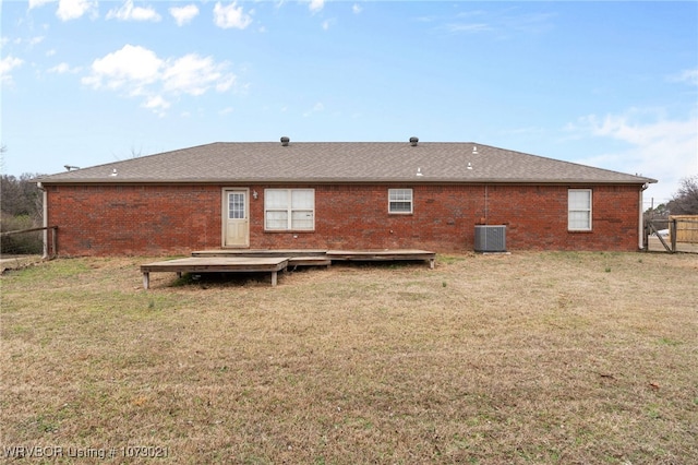 rear view of property with cooling unit, a yard, and a deck