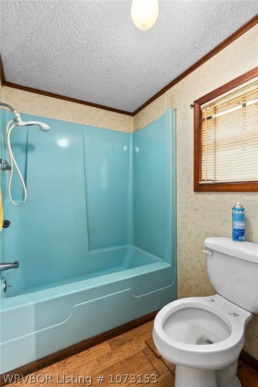 bathroom with shower / bath combination, hardwood / wood-style floors, ornamental molding, and toilet