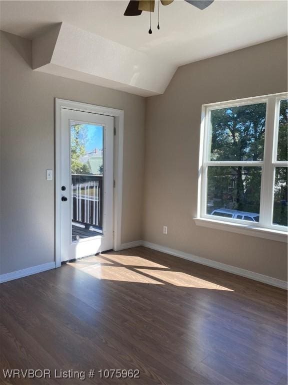 empty room featuring ceiling fan, dark hardwood / wood-style flooring, and vaulted ceiling