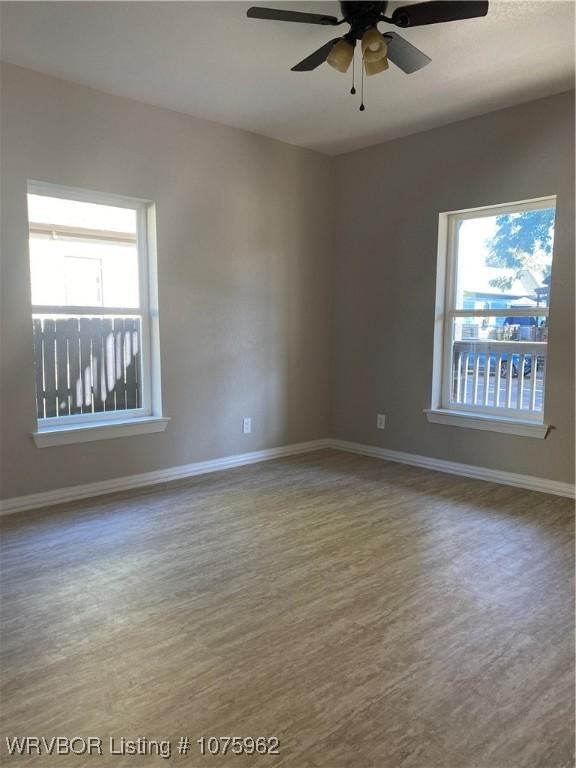 unfurnished room with ceiling fan and wood-type flooring