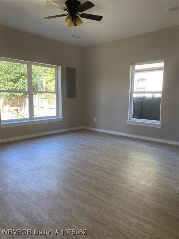 unfurnished room featuring electric panel, ceiling fan, and wood-type flooring