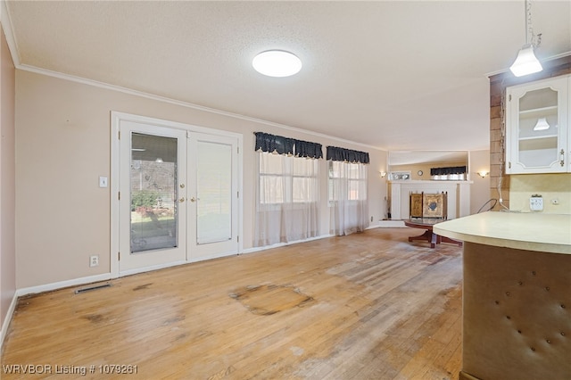 interior space with visible vents, hanging light fixtures, crown molding, french doors, and light wood-type flooring