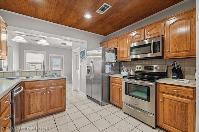 kitchen featuring light tile patterned floors, stainless steel appliances, a sink, visible vents, and tasteful backsplash