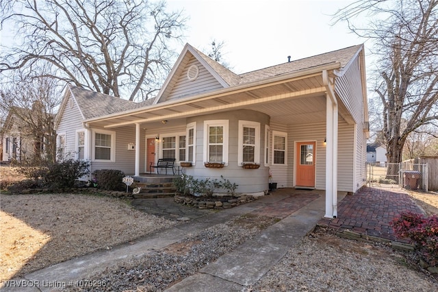 view of front of home featuring a porch, a shingled roof, fence, and a gate