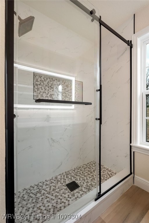 full bathroom with wood finished floors and a marble finish shower