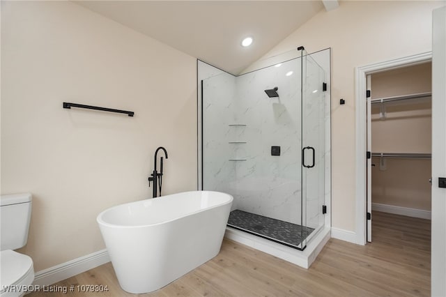 bathroom featuring lofted ceiling, toilet, wood finished floors, baseboards, and a marble finish shower