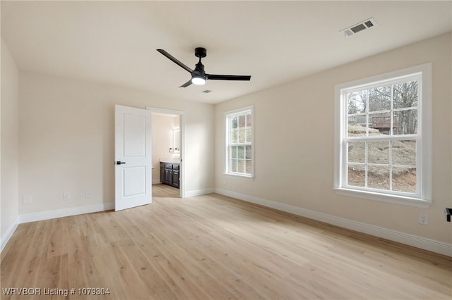 unfurnished bedroom featuring visible vents, ensuite bathroom, ceiling fan, light wood-type flooring, and baseboards