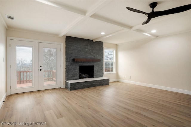 unfurnished living room featuring a fireplace, wood finished floors, visible vents, baseboards, and beam ceiling