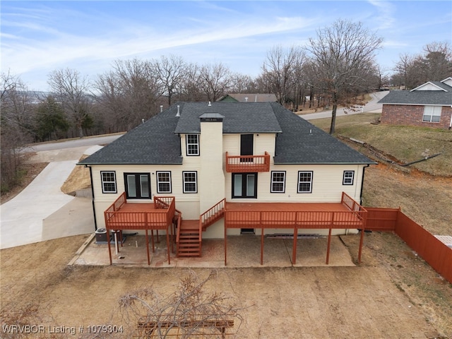 rear view of property with a patio, a balcony, central AC, stairs, and roof with shingles