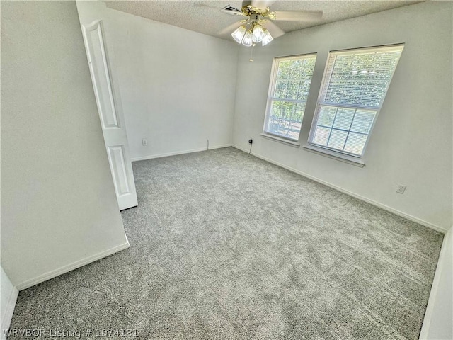 carpeted empty room featuring ceiling fan and a textured ceiling