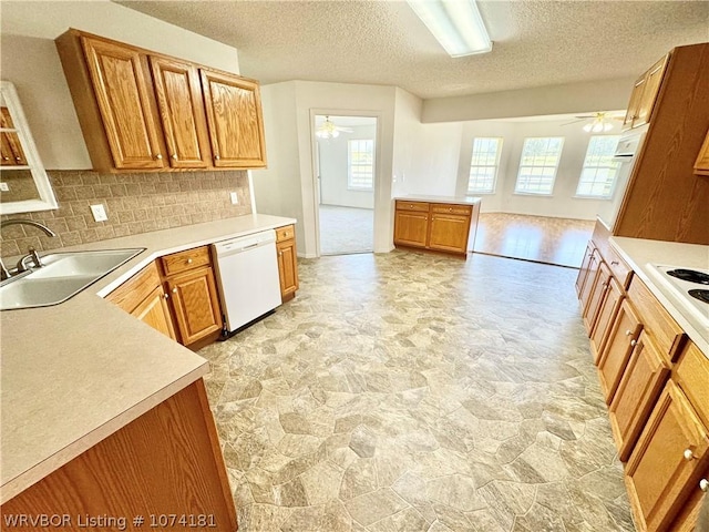 kitchen with dishwasher, a textured ceiling, ceiling fan, and sink