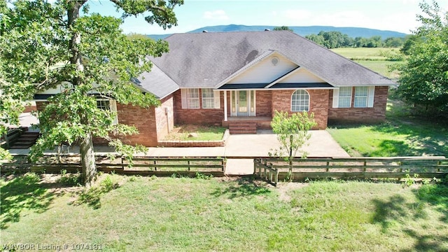 view of front of house with a mountain view and a front yard