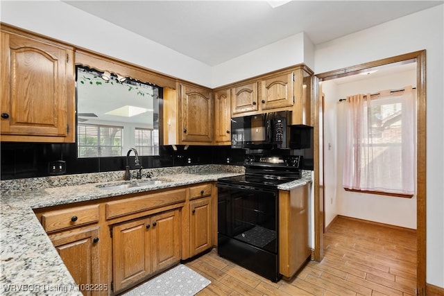3017 Canongate Way, Fort Smith, AR 72908 - kitchen with black appliances, light wood finished floors, brown cabinets, and light stone counters