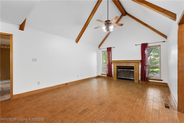 3017 Canongate Way, Fort Smith, AR 72908 - unfurnished living room featuring beam ceiling, light wood-style floors, a glass covered fireplace, a ceiling fan, and high vaulted ceiling