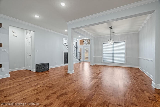 unfurnished living room featuring recessed lighting, stairway, crown molding, baseboards, and hardwood / wood-style floors
