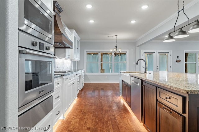 12200 Stonechase Dr, Fort Smith, AR 72916 - kitchen featuring stainless steel appliances, dark wood-style floors, ornamental molding, light stone countertops, and white cabinets