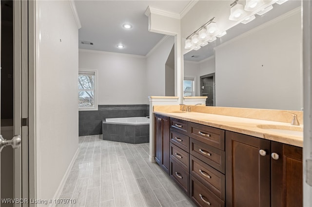 bathroom featuring double vanity, a bath, a sink, visible vents, and crown molding