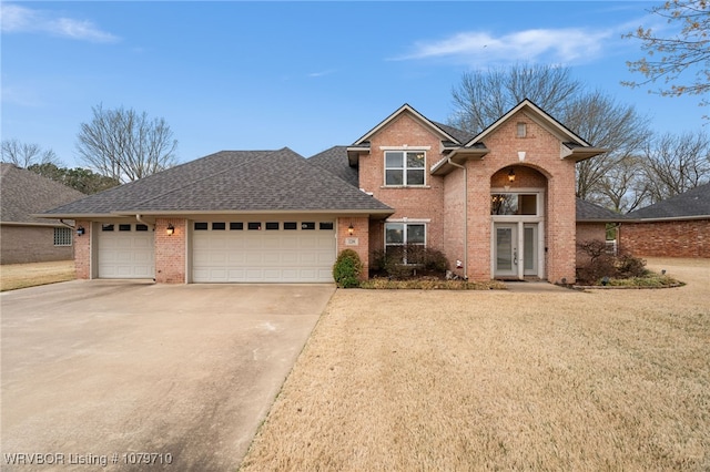 traditional-style home featuring brick siding, a garage, driveway, roof with shingles, and french doors